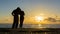 Young couple of lovers holding hands towards the sea at sunset. Man and woman in love