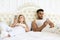 Young Couple Lying Separate In Bed, Serious Upset Hispanic Man And Woman Using Cell Smart Phone