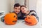 Young couple making jack-o-lantern for halloween on kitchen. Happy man and woman prepared pumpkins for holiday