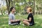 Young couple making a meditation to calm their mind after exercising in park with a warm light sunshine in afternoon.