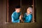 Young couple of malay muslim in traditional costume having romantic conversation during Aidilfitri celebration at wooden window of