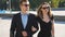 Young couple of male and female business people walking in the city street. Portrait of businessman and businesswoman