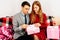 young couple  man and woman celebrate Valentine\'s Day at home and give each other gifts