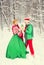 Young couple, man and woman, husband and wife are walking in costumes of flowers typical of the elves of Santa`s helpers in a win