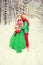 Young couple, man and woman, husband and wife are walking in costumes of flowers typical of the elves of Santa`s helpers in a win