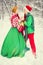 Young couple, man and woman, husband and wife are walking in costumes of flowers typical of the elves of Santa`s helpers in a win