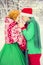 Young couple, man and woman, husband and wife are walking in costumes of flowers typical of the elves of Santa`s helpers in a win