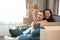 Young couple man and woman looking happy having break on the sofa during moving to new appartment unpacking boxes, , moving