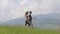 Young couple man and woman walking outdoors in summer mountains.