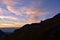 Young couple in mountain admiring beautiful light after sunset