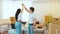 Young couple move into new apartment. Guy hold woman`s hand up and spin her around. Cheerful positive and happy couple