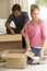 Young Couple Moving Into New Home Unpacking Boxes