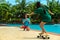 Young couple near swimming pool. Sexy woman with fit body riding on skateboards, and her boyfriend taking photo