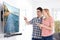 Young Couple With New Curved Screen Television At Home