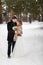 Young couple newlyweds walking in a winter forest in the snow.