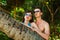 Young couple next to a palm tree in the jungle on a tropical isl