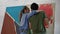 Young couple paints on canvas drawing picture in art studio, woman kiss a man