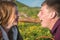 Young couple on a picnic simultaneously bite a baguette against the background of flowering meadows of the Caucasus