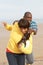 Young Couple Playing Rugby On Autumn Beach Holiday