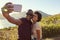 Young Couple Pose For Holiday Selfie On Clifftop