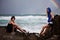 Young Couple Posing on Rocks By Stormy Ocean