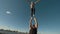 Young couple practicing acrobatics performing stunts outdoors at sunset