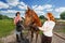 Young couple preparing for horseback ride at farm