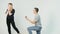 Young couple of pretty girl with long hair and handsome young man sitting on knees makes proposal on white background