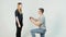 Young couple of pretty girl with long hair and handsome young man sitting on knees makes proposal on white background