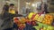 Young couple protective masks and gloves chooses fruits at the market