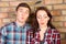 Young Couple Puckering Lips in front of Brick Wall