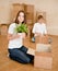 Young couple puts things in cardboard boxes for moving into a new house