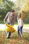 Young couple raking autumn leaves