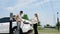 Young couple recharge EV car battery at charging station. Expedient