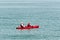 Young couple in red kayak fishing on tropical waters