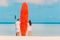 Young couple with red surfboard during tropical vacation