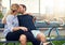 Young couple relaxing on a bench enjoying a kiss