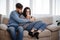 Young couple relaxing at home sitting at sofa