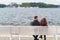 Young couple relaxing on a waterfront promenade.