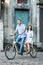 Young couple on retro tandem bicycle at the street city