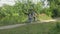 A young couple rides a tandem two-seater bike along the riverbank