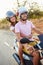 Young Couple Riding Motor Scooter Along Country Road