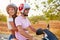 Young Couple Riding Motor Scooter Along Country Road