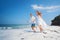 Young couple run by black sand beach along sea surf