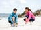 Young couple of runners tying shoelace at the seaside