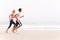 Young Couple Running Along Winter Beach