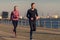 Young couple running on a seafront promenade