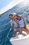 Young couple at sailboat wheel in caribbean sea