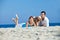 Young couple at sea side playing with their dog