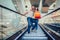 Young couple with shopping bags going down by escalator